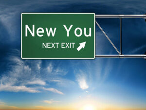 Highway sign reading “NEW YOU Next Exit” against a blue sky representing moving forward after divorce and personal growth